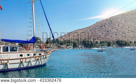 View Of The Embankment Of A Resort Town In Turkey With Boats Moored At The Pier, Palm Trees Overlook