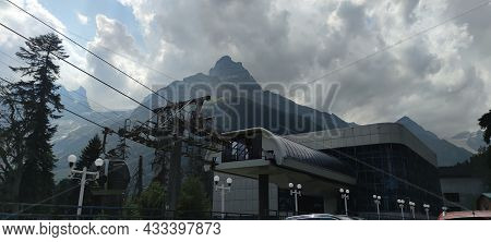 Dombay, Russia, August 28, 2021: Cabins Of The Ski Lift Against The High Snow-capped Caucasus Mounta