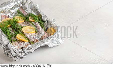 Congrio Fish In Sour Cream Filling Is Laid Out On Foil, Sprinkled With Seasoning, Lemons And Dill On