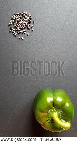 Black, Green And Red Peppercorns With Fresh Green Pepper On A Black Background