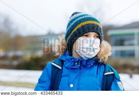 Kid Boy Wearing Ffp Medical Mask On The Way To School. Child Backpack Satchel. Schoolkid On Cold Aut