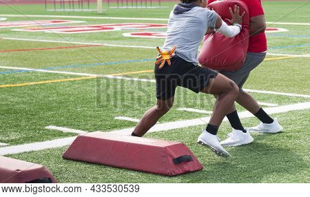 A High School Football Player Hits The Pad His Coach Is Holding After He Runs Sideways Over Red Barr