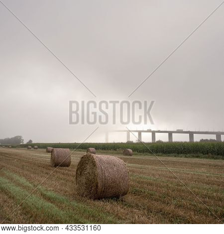 Meadow Landscape And Pont De Brotonne Over River Seine In French Normandy During Misty Sunrise