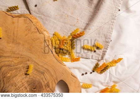 Fragment Of Cutting Board Curved Shape Of Olive Tree, Scattered Around Pasta, Garlic, Pepper. They L