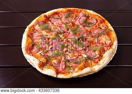 A Whole Rustic Pizza With Fried Mushrooms, Bacon, Onion And Tomatoes