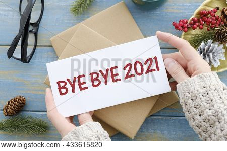 Text Bye Bye 2021 On White Paper On Red Christmas Background. Farewell To 2021 Concept.