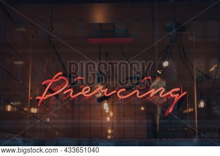 London, Uk - September 03, 2021: Piercing Neon Sign In A Window Of Rachels Salon In East End Of Lond
