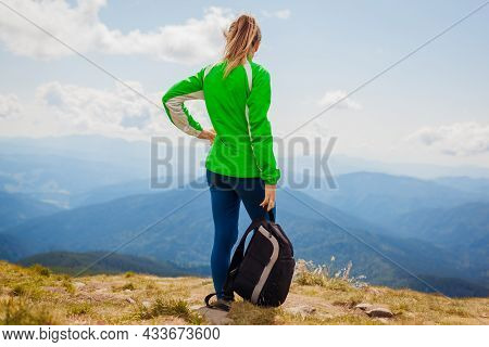 Trip To Carpathian Mountains. Happy Woman Tourist Hiker With Backpack Admires View On Top Of Hoverla