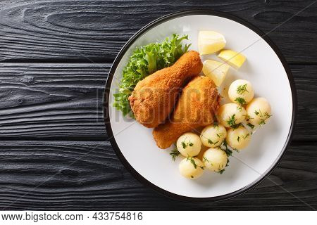 Austrian Fried Chicken Backhendl Served With Lemon And New Potatoes Close Up In The Plate On The Tab