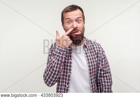 Portrait Of Funny Silly Bearded Man In Casual Plaid Shirt Picking Nose And Showing Tongue With Comic