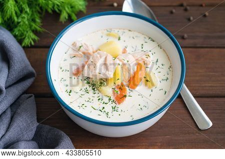 Salmon Soup With Cream, Potatoes, Carrots And Herbs In A Bowl On A Dark Wooden Background. Lohikeitt