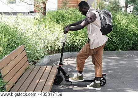 Horizontal Side View Long Shot Of Young African American Guy Wearing Casual Outfit With Backpack Par