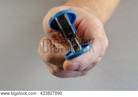 Hand Reaches Into The Camera Staple Remover. Clerical Device For Removing Staples From Documents. Cl