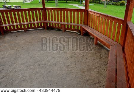 Polygonal Pergola With Benches And A Fence Around The Perimeter. There Is A Lot Of Space Inside. The