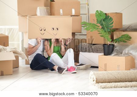 Happy couple in their new home having fun - moving concept