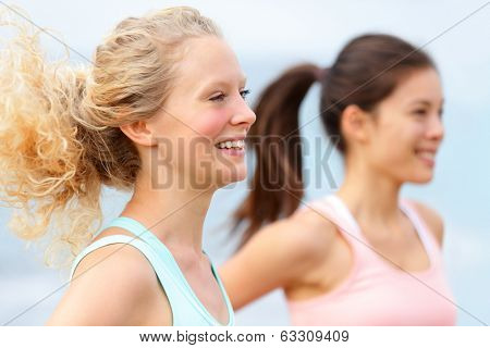 Running women runners training outdoors. Close up portrait of happy woman runner jogging outside with friends on beach.