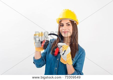 Young woman wearing a yellow hard hat and full protective gear smiling at the camera.