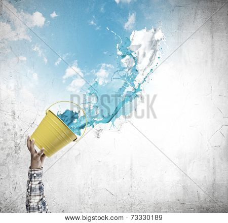 Close up of hand splashing colorful paint from bucket