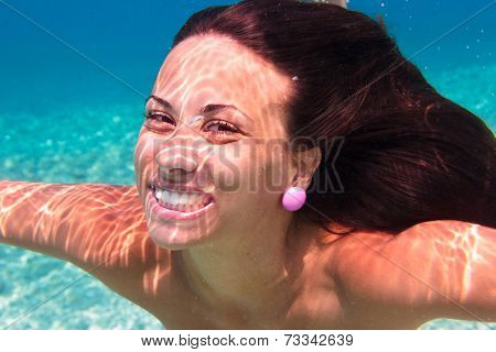 Young woman swimming undewater in the sea
