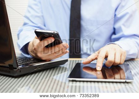 Businessman Is Working On Tablet And Using Smart Phone In Office With Laptop