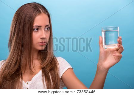 Portrait of young beautiful girl holding a glass with clean wate