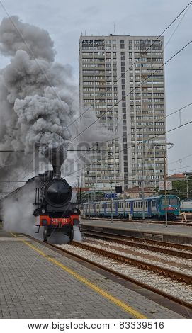 Steam locomotive leaving the station in clouds of smoke