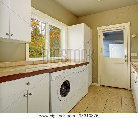 Laundry Room With Tile Counters And Sink.