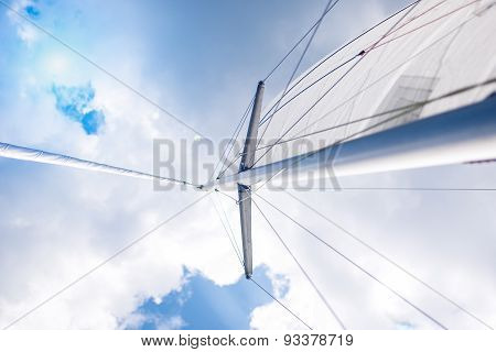 Closeup View Of Mid-size Yacht Mast And Canvas Sail Shot Against Bright Summer Sun.