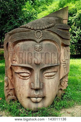 Deyang China - July 8 2007: Sculpted head of Buddha displayed on a lawn at Stone Carvings Park