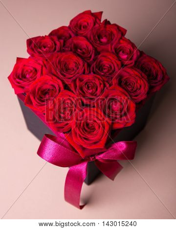 Close Up Of Box With Red Roses Over Beige Background