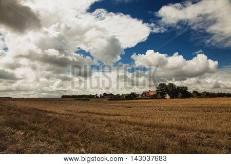 cloudy autumn sky over danish fields and houses