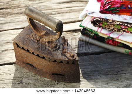 Old vintage iron on the charcoal on wooden background