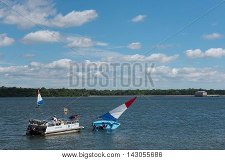 Mannesquan Reservoir Howell NJ USA -- Aug 17 2016 Park Ranger moves to rescue a passenger in a sailfish that is tipping over. Editorial Use Only.