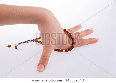 Hand holding a tespih on a white background