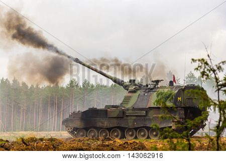 german self-propelled howitzer shoots on a battlefield