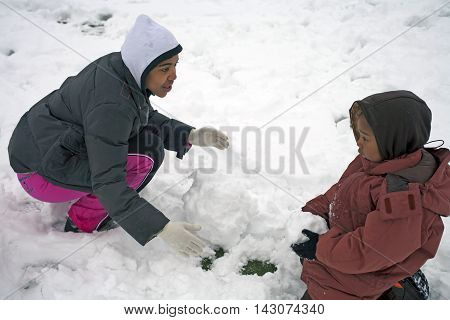 BRONX NEW YORK - FEBRUARY 22: Mother with child play with snow in park after snow storm. Taken February 22 2009 in New York.