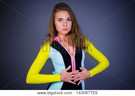 Serious girl portrait in sportwear body on gray background