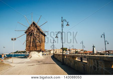 A man takes a photo an old windmill on the way to the unesco world heritage city Nessebar in Bulgaria.