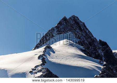 Snowy mountain peak. Mountaineering rock climbing. Group of mountaineers climbing mountain ridge to top
