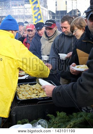 CRACOW POLAND - DECEMBER 20 2015: Christmas Eve for poor and homeless on the Central Market in Cracow. Every year the group Kosciuszko prepares the greatest eve in the open air in Poland