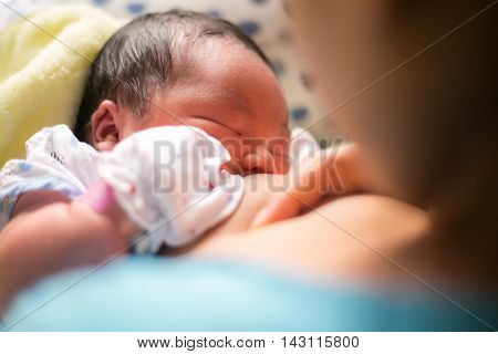 breastfeeding. mother holding newborn baby in an embrace and breastfeed