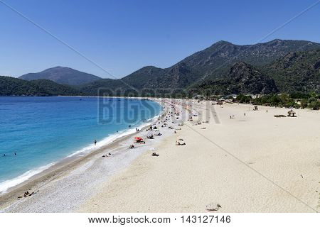 OLUDENIZ TURKEY - JUNE 04: Tourists visit Oludeniz beach in Turkey on JUNE 04 2016. Oludeniz beach is one of the best beaches in Turkey it's situated on Mediterranean Sea