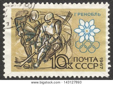 MOSCOW RUSSIA - CIRCA JUNE 2016: a post stamp printed in the USSR shows hockey players the series "Winter Olympic Games - Grenoble 1968 France" circa 1967