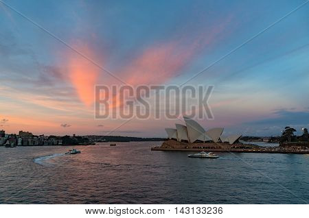 Sydney Australia - Jul 10 2016: Sydney Opera House at sunset. Iconic Sydney architectural sightseeing and water transport against colorful sky on the background. Circular Quay CBD
