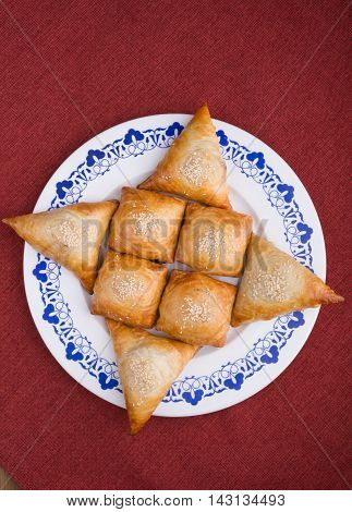 Fresh baked samosas on a big dish