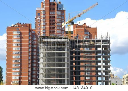 Building of the many-storeyed house against the background of the finished house