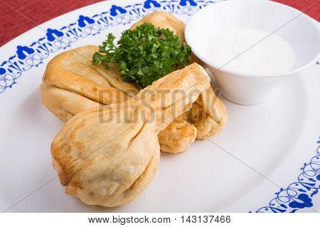 Traditional caucasian dumplings served with sour cream