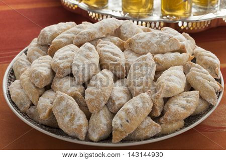  Traditional Moroccan makrout, date cookies, on a dish and tea