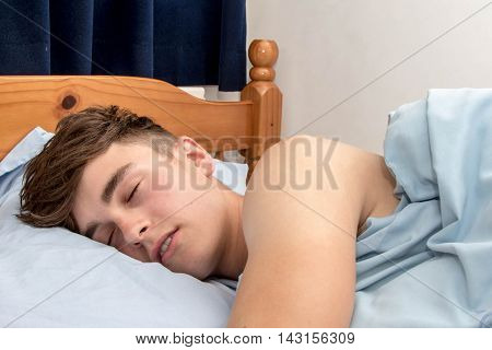 Teenage boy fast alseep in his bed