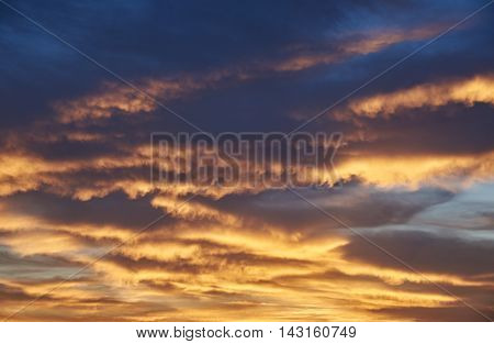 Rain cumulus clouds sundown. Clouds of orange and golden. Background